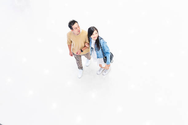 istock Asian Couple Walking Through a Brightly Lit Shopping Mall 1137484345