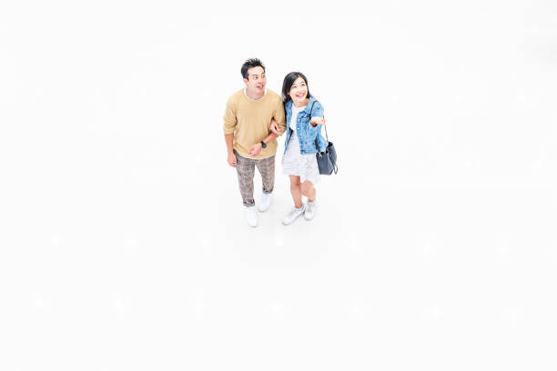istock Asian Couple Walking Through a Brightly Lit Shopping Mall 1137484351