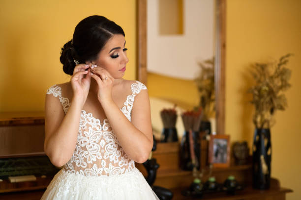 istock brunette bride putting her earrings 1137486003