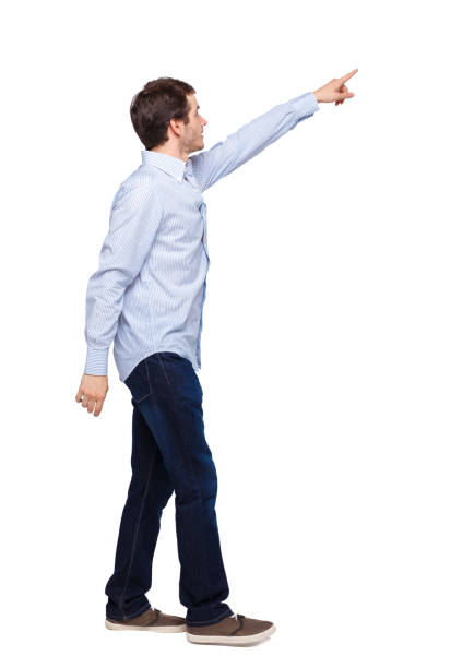 istock Back view of a man walking with a pointing hand. 1137488122