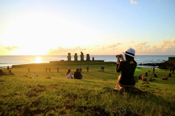 female tourist taking photos of the famous sunset scene at ahu tahai, easter island - ahu tahai imagens e fotografias de stock