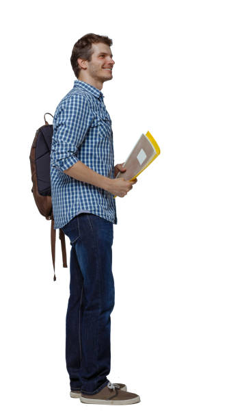 istock Side view of a student . The guy with the backpack and textbooks. 1137491749