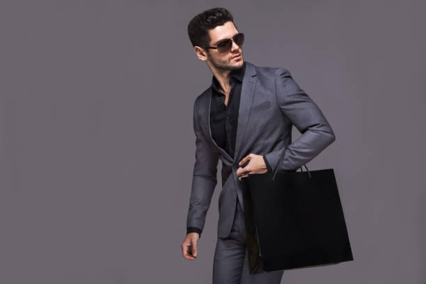 istock Handsome man in suit with shopping bag 1137495242
