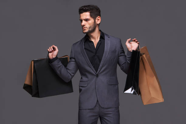 istock Handsome man in suit with shopping bag 1137495253