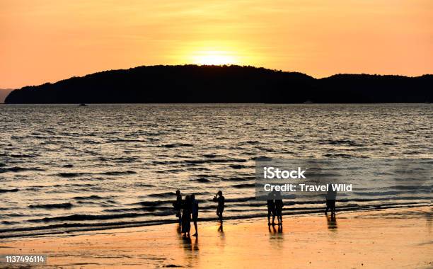 Blurry Silhouette Of Some Non Unidentified People Enjoying The Stunning Sunset On A Beautiful Beach Bathed By A Smooth Sea Ao Nang Beach Krabi Province Thailand Stock Photo - Download Image Now