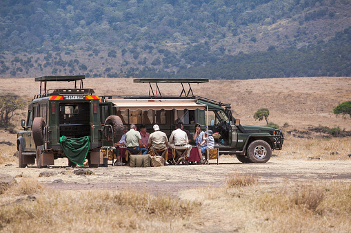 Ngorongoro, Tanzania: September, 2014: Tourists are having a lunch near their safari car near lake at the bottom of Ngorongoro Crater