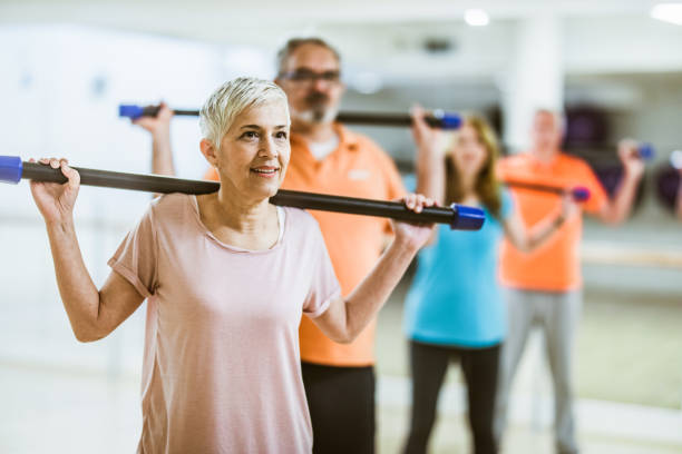 istock Mature woman practicing with bar during exercise class in a gym. 1137501841