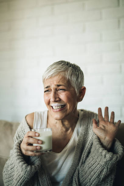 istock Cheerful mature woman having fun while drinking milk at home. 1137507074