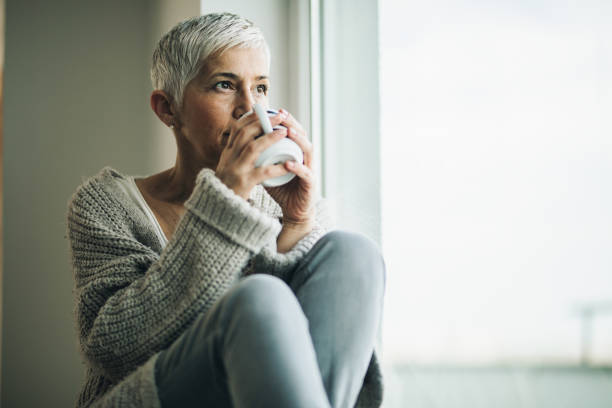 istock Pensive mature woman drinking coffee by the window. 1137507571