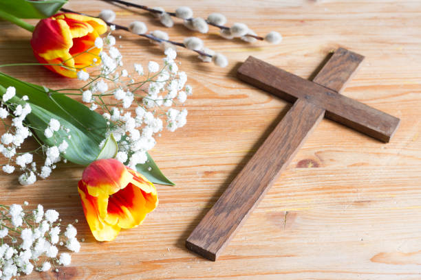 istock Spring easter flowers and cross on wooden background 1137512108