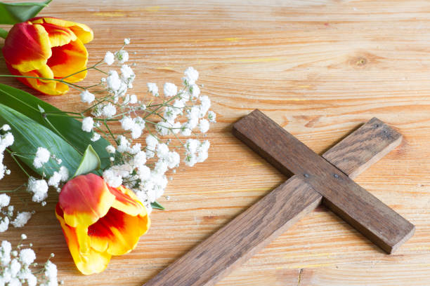 istock Spring easter flowers and cross on wooden background 1137512126
