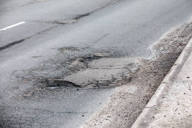 istock Damaged asphalt road with potholes 1137516135