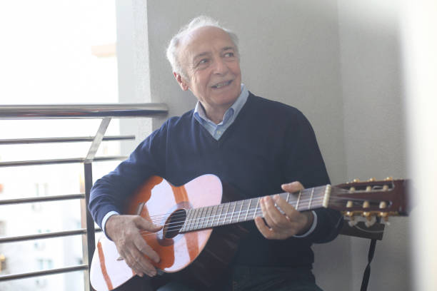 istock Senior man playing a guitar on a balcony 1137518292