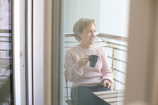 istock Senior woman sitting on a balcony 1137518414