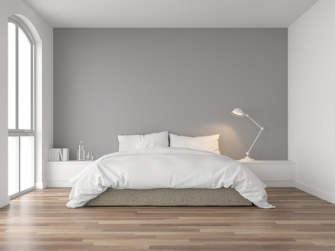 Minimal bedroom 3d render,There are wood floor and  gray wall.Furnished with brown fabric bed and white blanket .There are arch shape window nature light shining into the room.