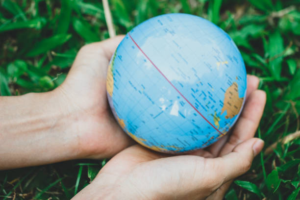 istock Female hands holding floating earth on natural green background. 1137518674