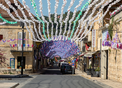 Saint Cyprien, France - September 4, 2018: Colourful street decorations during the summer Felibree in Saint Cyprien, France. A felibree is a traditional Occitan festival which takes place every year in a town or village in the Dordogne.