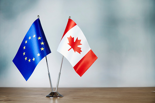 European Union and Canada flag standing on the table with defocused background