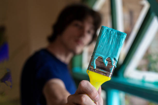 istock Man paints a wooden window frame turquoise 1137521648