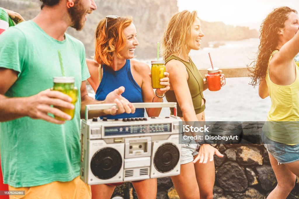 Glückliche Freunde, Cocktails trinken und Musik aus alten Vintage-Stereo hören-Junge Trendmenschen, die Spaß an der Sommerstrand-Party haben-Jugend Lifestyle und festes Konzept-Fokus auf blondes Mädchengesicht - Lizenzfrei Strand Stock-Foto