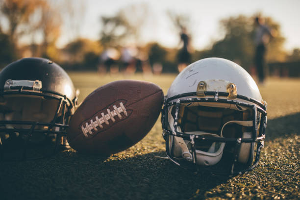 istock Football helmets and ball on grass 1137526051