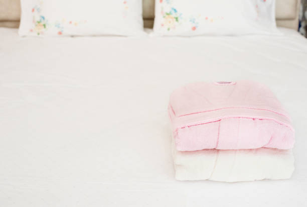 istock Folded bathrobe on bed in room. White and pink, two robes 1137526898