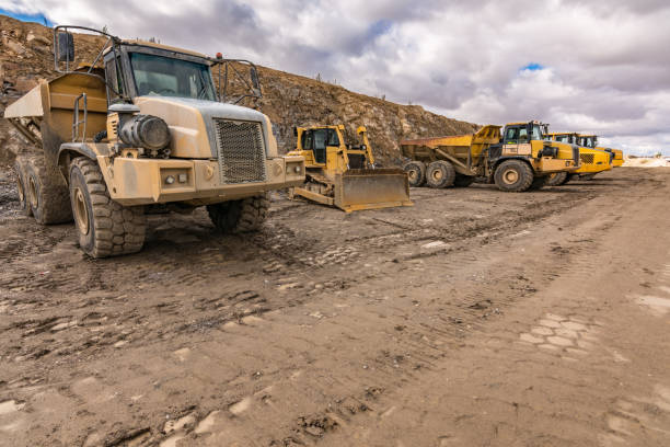 fleet of trucks and an excavator on a construction site - parking lot imagens e fotografias de stock