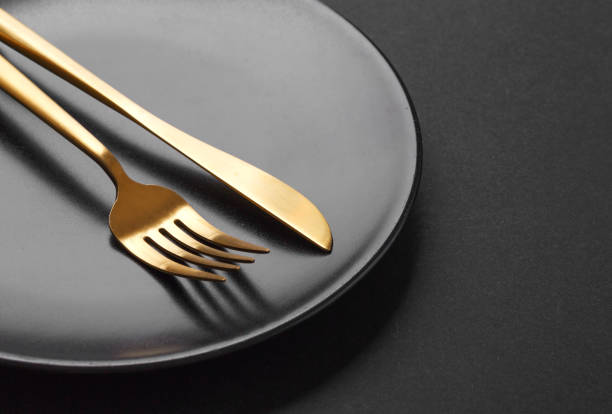 istock Gold cutlery set on black background 1137530147