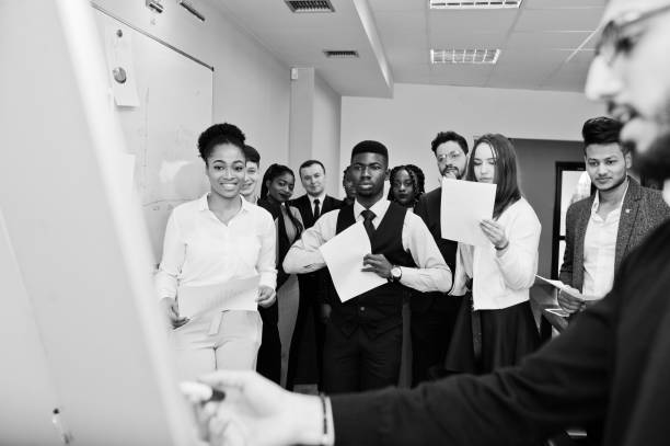 istock Arabian business coach presenting report standing near whiteboard pointing on sales statistic shown on diagram and chart teach diverse multiracial company members gathered together in conference room. 1137533661