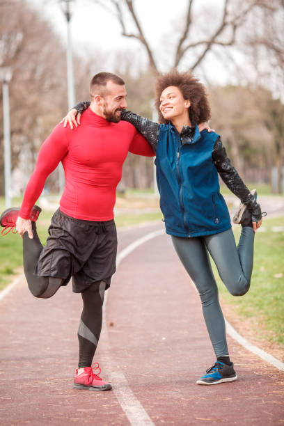 istock Young athletic couple stretching while embracing each other on an all-weather running track in a city park 1137535032