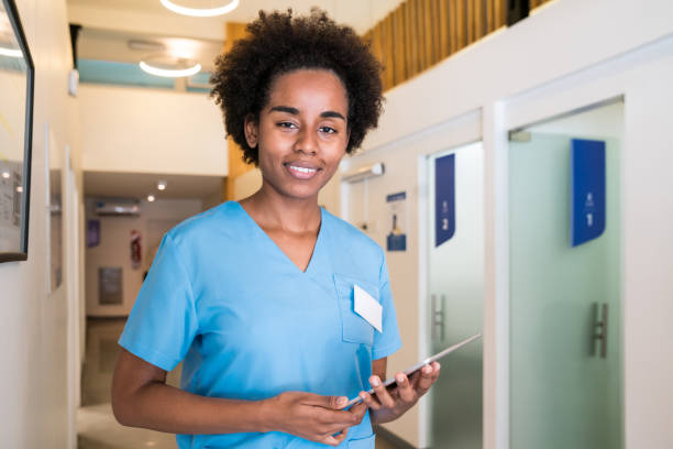 istock Smiling young female nurse holding digital tablet 1137538965