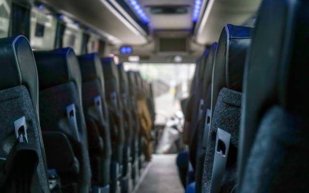 view from back seat at coach bus, more seats in blurred background - interior de transporte imagens e fotografias de stock