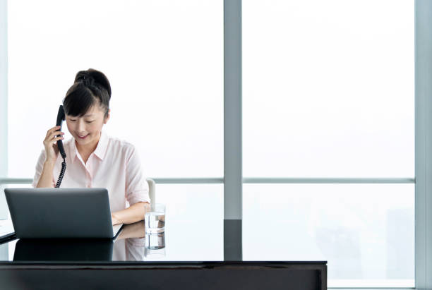 istock Businesswoman using telephone and laptop in office 1137540427