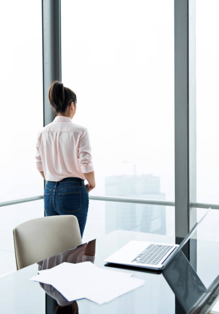 istock Businesswoman standing in front of window 1137540948