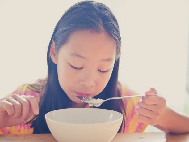 istock Cute Asian girl eats rice soup for breakfast 1137541865