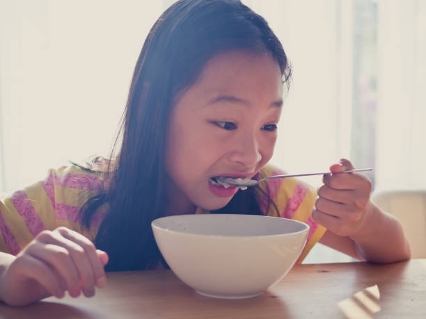 istock Cute Asian girl eats rice soup for breakfast 1137541869