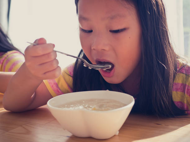 istock Cute Asian girl eats rice soup for breakfast 1137541884