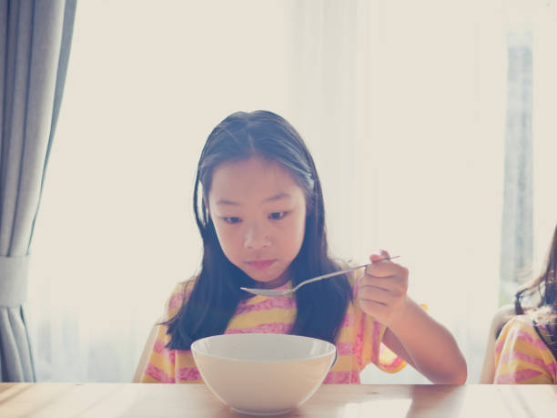 istock Cute Asian girl eats rice soup for breakfast 1137541894