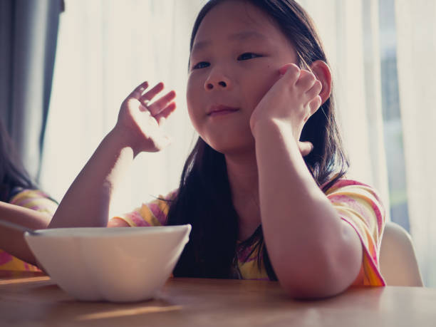 istock Cute Asian girl eats rice soup for breakfast 1137541898