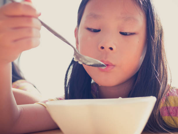 istock Cute Asian girl eats rice soup for breakfast 1137541902