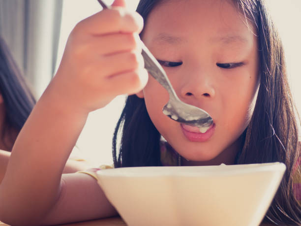 istock Cute Asian girl eats rice soup for breakfast 1137541907
