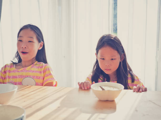 istock Cute Asian girl eats rice soup for breakfast 1137541912