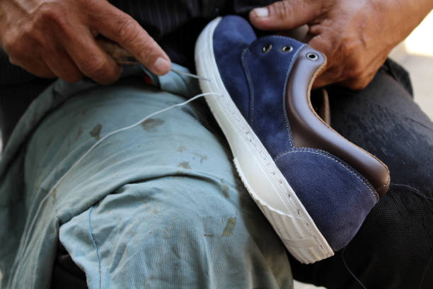 istock Process of manual shoe reparation, sole and welt fixing and stitching. 1137542078