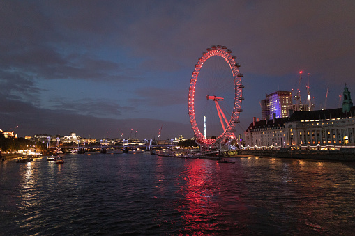 Beautiful London eye on Thames river at night, side view