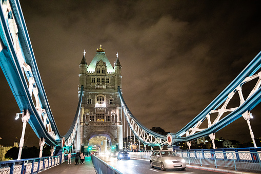 Low angle view of Tower Bridge at night, with traffic and street lights