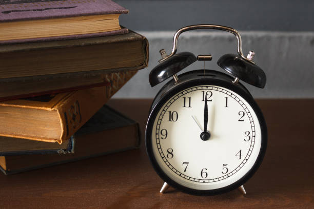 istock piles of different old books on a dusty table and an alarm clock 1137544162