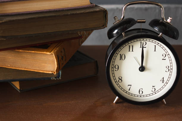 istock piles of different old books on a dusty table and an alarm clock 1137544170