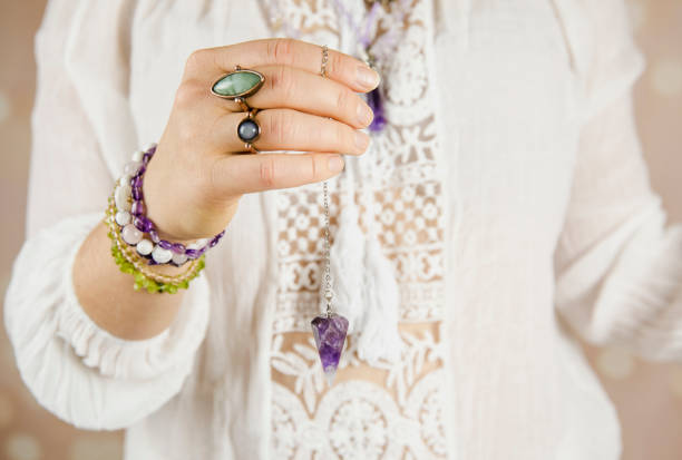 Light angel magic clairvoyant using pendulum, reading palm to get answers. Talking with spirits concept.