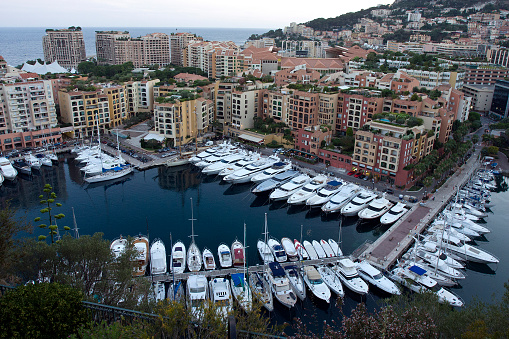 A harbor with boats surrounded by buildings in the rocky mountains in Nice, France