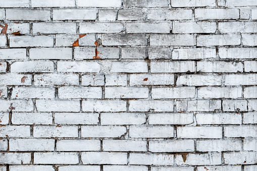 Old vintage brick wall with peeling plaster.